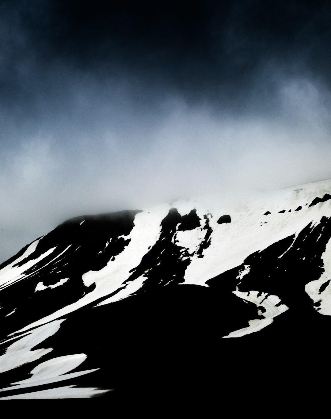 Dramatic snow-capped mountains with dark rock formations